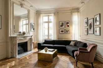 Salon haussmannien revisité avec canapé contemporain, moulures classiques et parquet en chevrons dans un appartement parisien